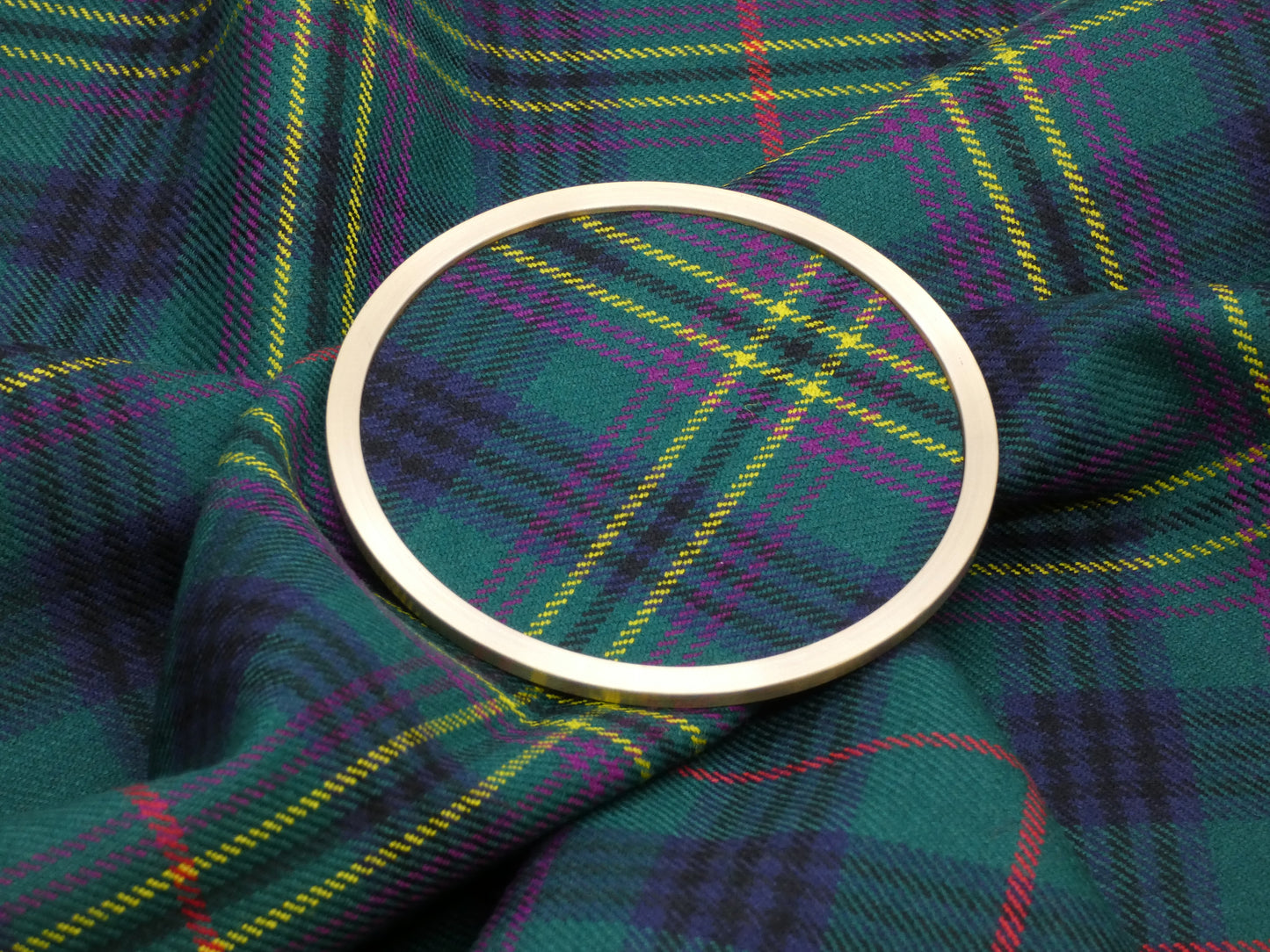 Clan Kennedy Ancient Tartan Brass Coaster on Tartan Fabric