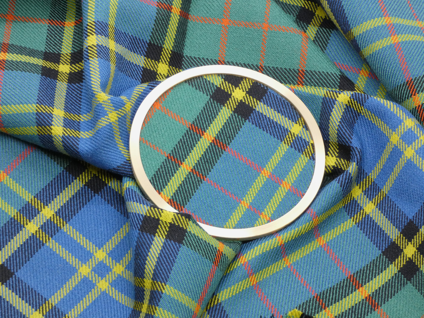 MacMillan Hunting Ancient Tartan Brass Coaster on Tartan Wool Fabric
