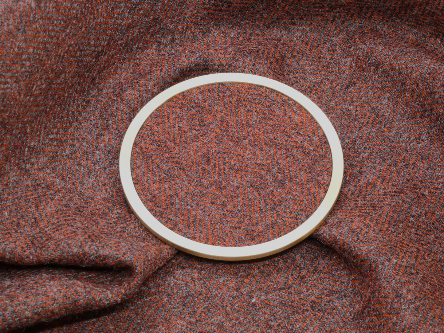 Red Herringbone Tweed Brass Coaster on Fabric