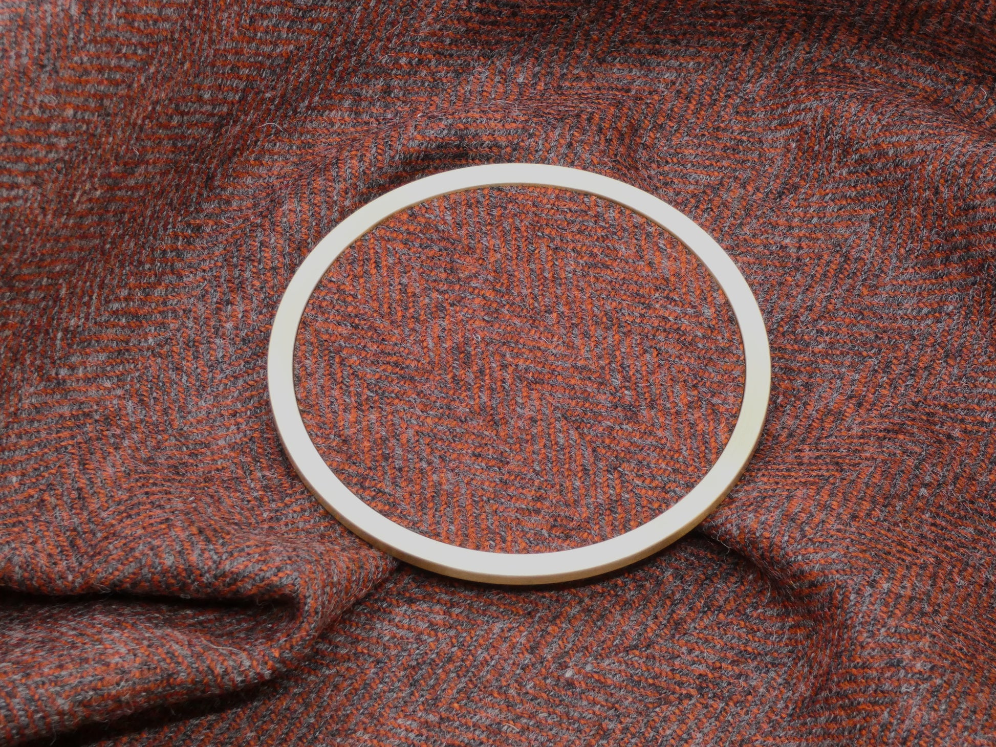 Red Herringbone Tweed Brass Coaster on Fabric